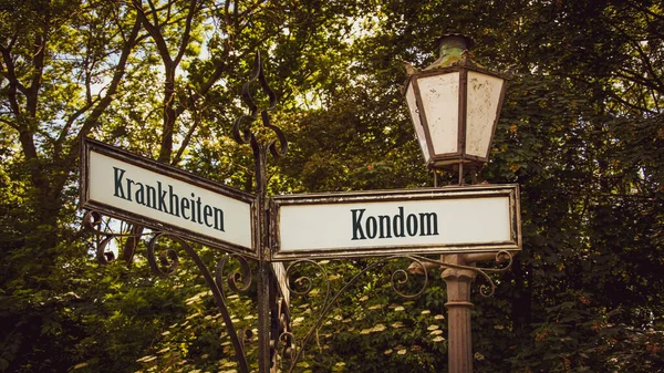 stock image An image with a signpost pointing in two different directions in German. One direction points to condoms, the other points to diseases.