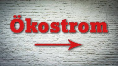 Yeşil elektrik yönünü işaret eden Almanca bir işaret direği olan bir resim.