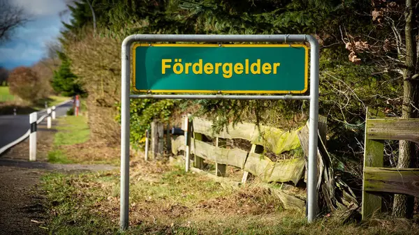 Stock image The picture shows a signpost and a sign that points in the direction of funding in German.