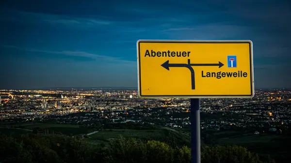 stock image An image with a signpost pointing in two different directions in German. One direction points to adventure, the other points to boredom.