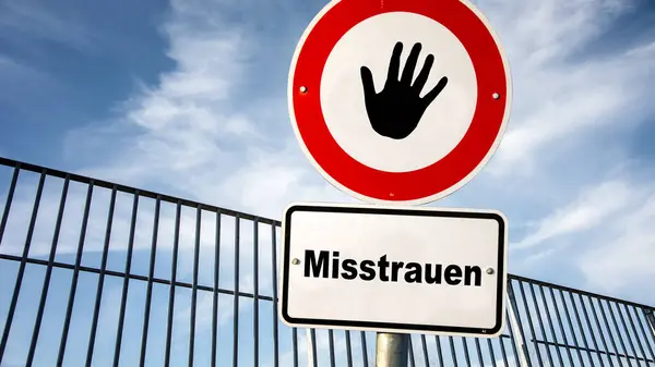 stock image An image with a signpost pointing in two different directions in German. One direction points to trust, the other points to mistrust.