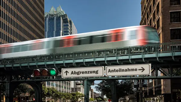 stock image An image with a signpost pointing in two different directions in German. One direction points towards participation, the other points towards differentiation.