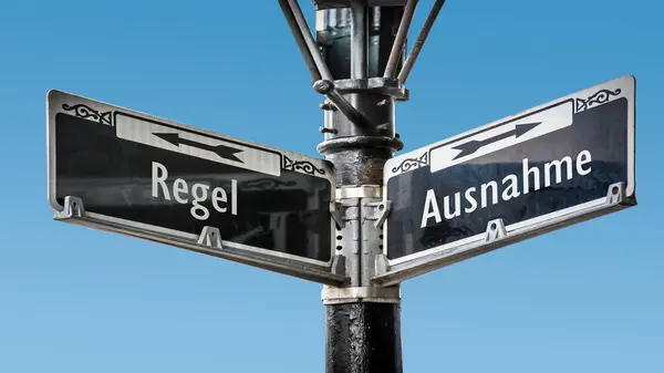 stock image An image with a signpost pointing in two different directions in German. One direction points by exception, the other points by rule.