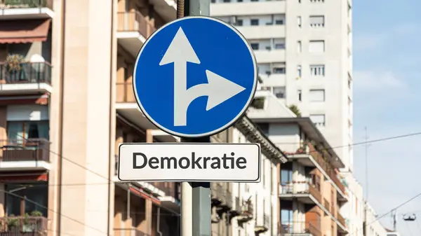 Stock image the picture shows a signpost and a sign that points in the direction of democracy in german.