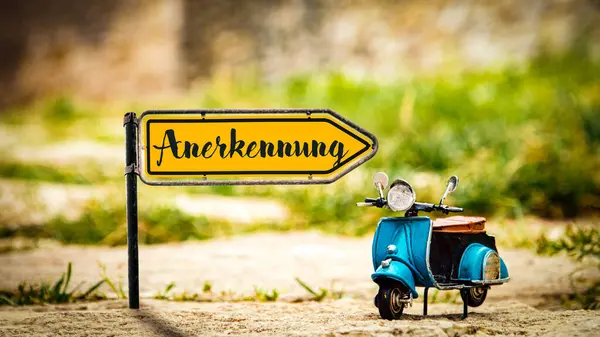 stock image Image showing a signpost and sign pointing in the direction of the recognition earned in German.