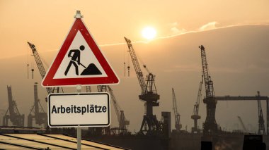 Resim Almanca işleri gösteren bir tabela ve tabela gösteriyor.