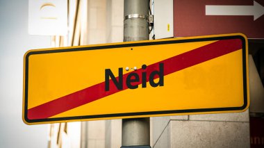 An image with a signpost pointing in two different directions in German. One direction points to favour, the other points to envy. clipart