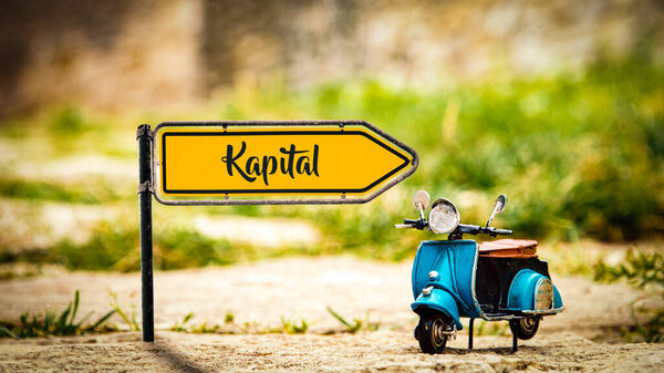 На картинке вывеска и знак, указывающий на немецкий язык в сторону столицы..