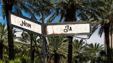 Almanca 'nın iki farklı yönünü gösteren işaret direği olan bir resim. Bir yön evet diyor, diğeri hayır..