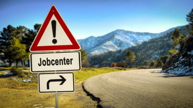 Resim bir tabela ve Almanca iş merkezinin yönünü gösteren bir tabela gösteriyor..