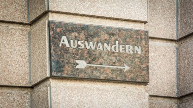 Görüntü, Almanca göç ve seyahat tutkusu yönünde bir tabela ve işaret gösteriyor..