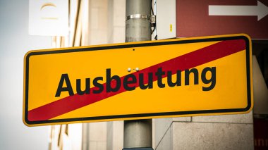 Almanca 'nın iki farklı yönünü gösteren işaret direği olan bir resim. Bir yön asgari ücrete, diğeri sömürüye işaret ediyor..