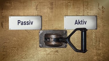 Almanca 'nın iki farklı yönünü gösteren işaret direği olan bir resim. Bir yön Aktif 'i, diğeri Pasif' i gösteriyor.