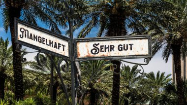 Almanca 'nın iki farklı yönünü gösteren işaret direği olan bir resim. Bir yön çok iyi, diğeri fakirleri gösteriyor..