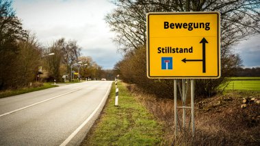 Almanca 'nın iki farklı yönünü gösteren işaret direği olan bir resim. Bir yön hareketi işaret eder, diğeri ise duraksamayı..