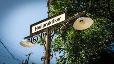 Resim, Almanca 'da Naturopath yönünü gösteren bir tabela ve tabela gösteriyor..