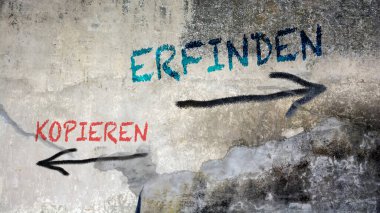 Almanca 'nın iki farklı yönünü gösteren işaret direği olan bir resim. Bir yön kopyalama, diğeri icat etme..