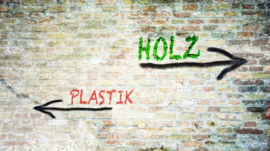 Almanca 'nın iki farklı yönünü gösteren işaret direği olan bir resim. Bir yön tahtayı, diğeri plastiği işaret ediyor..