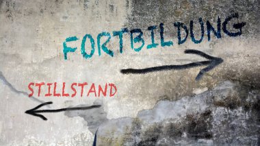 Almanca 'nın iki farklı yönünü gösteren işaret direği olan bir resim. Bir yön ileri eğitime, diğeri durgunluğa işaret ediyor..