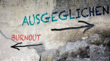 Almanca 'nın iki farklı yönünü gösteren işaret direği olan bir resim. Bir yön Dengeli 'yi, diğeri Burnout' u gösteriyor.