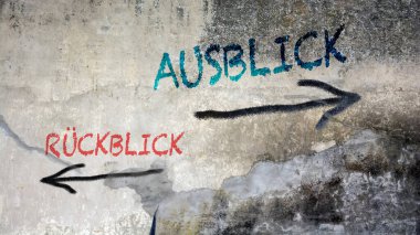 Almanca 'nın iki farklı yönünü gösteren işaret direği olan bir resim. Bir yön bakış açısını, diğeri arka planı gösteriyor.
