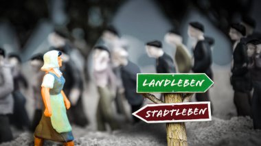 Almanca 'nın iki farklı yönünü gösteren işaret direği olan bir resim. Bir yön köy yaşamını, diğeri şehir yaşamını gösteriyor..