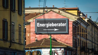 Resim bir tabela ve Almanca Enerji Danışmanının yönünü gösteren bir tabela gösteriyor..