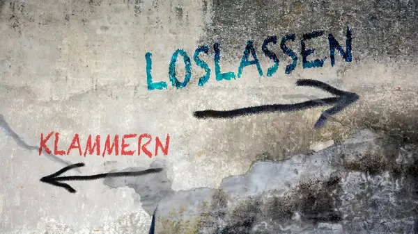 Almanca 'nın iki farklı yönünü gösteren işaret direği olan bir resim. Bir yön serbest bırakmayı işaret ediyor, diğeri de bırakmayı..