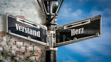 Almanca 'nın iki farklı yönünü gösteren işaret direği olan bir resim. Bir yön kalbi gösterir, diğeri zihni..