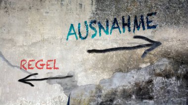 Almanca 'nın iki farklı yönünü gösteren işaret direği olan bir resim. Bir yön istisna, diğeri kural olarak noktalar.