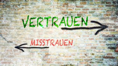 Almanca 'nın iki farklı yönünü gösteren işaret direği olan bir resim. Bir yön güveni gösterir, diğeri güvensizliği..