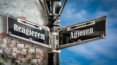 Almanca 'nın iki farklı yönünü gösteren işaret direği olan bir resim. Bir yön harekete geçmeyi, diğeri tepki vermeyi işaret eder..