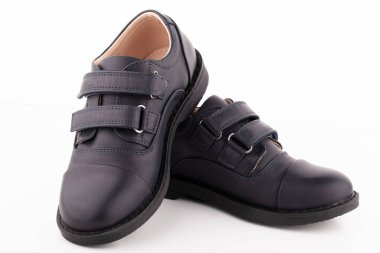 Beyaz arka planda bir çift siyah deri ayakkabı..