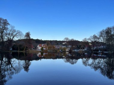 Kışın göl. Mavi gökyüzü. Sudaki yansımalar.