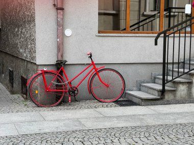 Verandanın yanında kırmızı bisiklet. Basamaklar. Avrupa taşra kasabası.