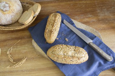 Lezzetli ve taze tahıllı ekmek çubuklarını kapayın ve arka planda çeşitli ekmekleri.