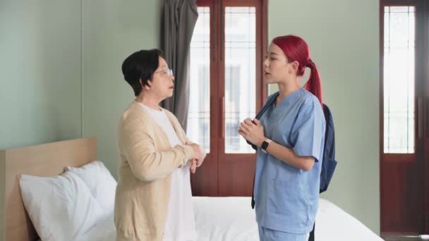 Старшая Азиатка Разговаривает Азиаткой Медсестрой Халате Спальне Посещение Сиделки Дома — стоковое видео