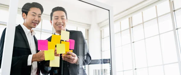 成功したアジアのビジネスマンのチームワークのグループ 新しいアイデアのためのガラスの壁に粘着性のある紙のメモとのブレインストーミング テクノロジースタートアップオフィスでのビジネスにアジャイル手法を活用 — ストック写真