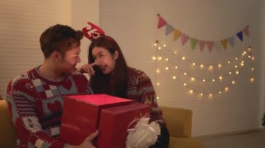 Mutlu bir Asyalı kız arkadaşının sürpriz bir hediye kutusunu içeriden gelen sihirli parlak ışıkla açar. Noel tatili boyunca evde birlikte yaşayan bir çift. Geceleyin, Noel günü..