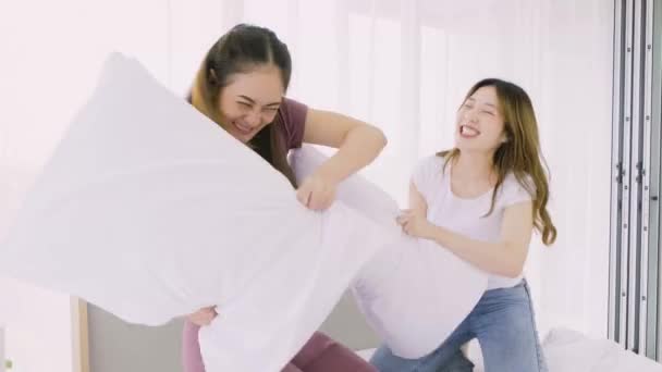 Two Happy Attractive Asian Women Having Pillow Fight Smiles Laugh — Stockvideo