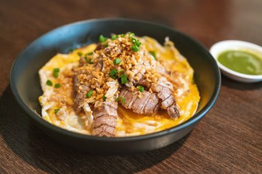 Pirinç üzeri kerevit omleti, taze kerevit parçalarıyla kabarık omlet buğulanmış pirinç tepeciğine konur ve dilimlenmiş soğanla kaplanır. Bangkok restoranındaki Çin kaynaklı menü.