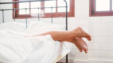Mutlu iki arkadaş, beyaz bornozlu beyaz kadınlar evdeki yatakta yatıyor. LGBTQ çiftler için spa ve tedavi aktiviteleri.