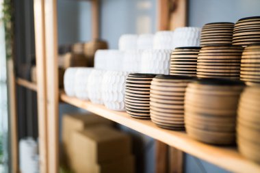 Vazo dükkanının rafındaki el yapımı ahşap vazo stoğunu kapat. Vazo stoku, hediyelik eşya veya ev dekorasyonu için raftaki çevrimiçi müşteriler için hazır..