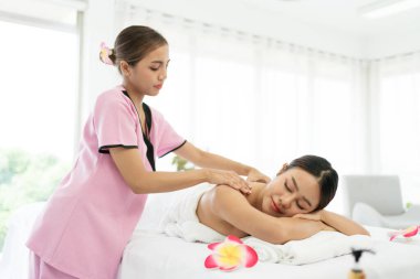 Asyalı genç bir kadın uzanıp masaj yataklarında gözlerini kapatırken Asya 'daki lüks bir spa salonu ve sağlık merkezindeki bir terapistten masaj alıyor. Spa salonu konseptini bekliyor.