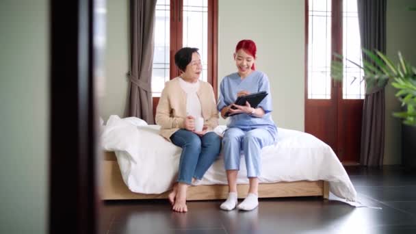 Aziatische Verpleegster Dragen Scrubs Melden Gezondheidsstatus Van Senior Aziatische Vrouw — Stockvideo
