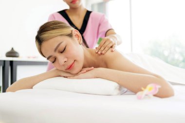 Asyalı genç bir kadın uzanıp masaj yataklarında gözlerini kapatırken Asya 'daki lüks bir spa salonu ve sağlık merkezindeki bir terapistten masaj alıyor. Spa salonu konseptini bekliyor.