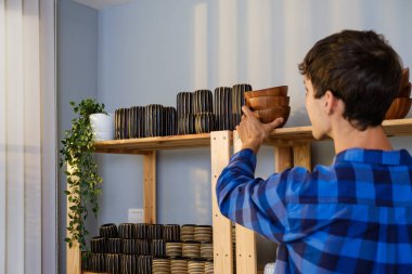 Beyaz erkek evde canlı yayın yapan vazo ürünleri satıyor. Genç ve çekici bir adam müşteriye malları gösteriyor ve ayrıntıları sunuyor. Uzak satın alma ve satın alma kavramı.