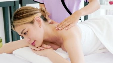 Asya 'da lüks bir spa salonunda ve sağlık merkezinde masaj yaparken rahatlatıcı genç bir Asyalı kadına masaj yapan bir terapistin yakın çekim elleri. Spa salonu konsepti