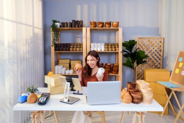 Asyalı güzel bir kadın evde canlı yayında vazo satıyor. Genç ve çekici bir kız müşteriye malını ve detaylarını gösteren akıllı telefon kullanır. Uzak satın alma ve satın alma kavramı.