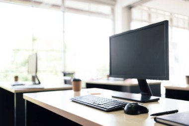 Modern çalışma ortamında ekranı, klavyesi, faresi, defteri, kalemi ve kağıt kahve fincanı olan modern kişisel ofis modeli. Kopyalama alanı olan resim.